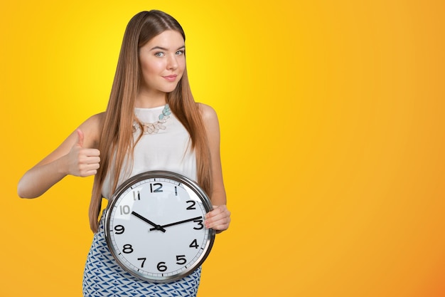 Portrait of beautiful young business woman holding in hands clock