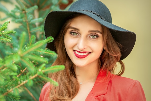 Portrait of a beautiful young caucasian woman with Christmas tree smiling