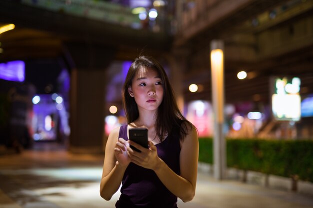 Portrait Of Beautiful Young Chinese Woman Outdoors At Night