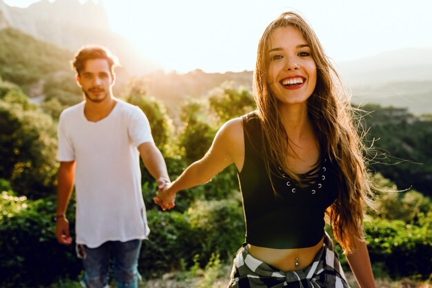 Portrait of beautiful young couple enjoying nature at mountain peak.