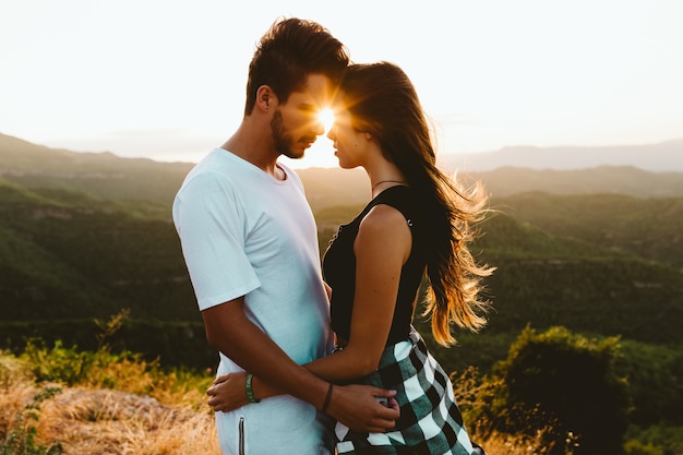 Portrait of beautiful young couple enjoying nature at mountain peak.