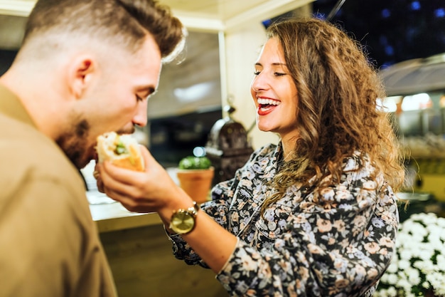 Portrait of beautiful young couple visiting eat market in the street.