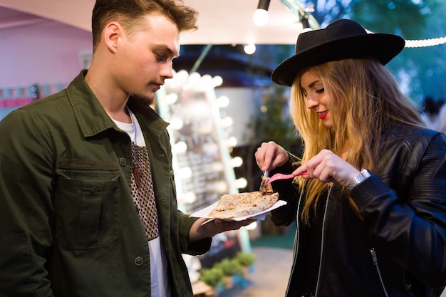 Portrait of beautiful young couple visiting eat market in the street.