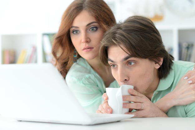 ノートパソコンを持つ美しい若いカップルの肖像画