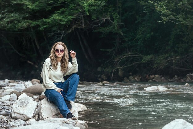 Portrait of a beautiful young female tourist traveling in the mountains