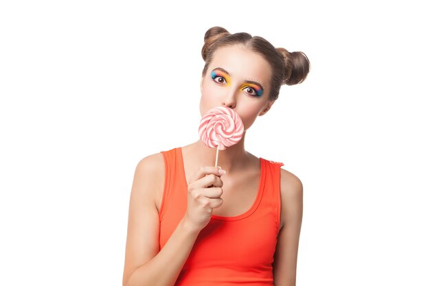 Portrait of beautiful young girl biting candy while looking at camera.Studio shot