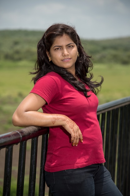 Portrait of beautiful young girl on the bridge near lake.