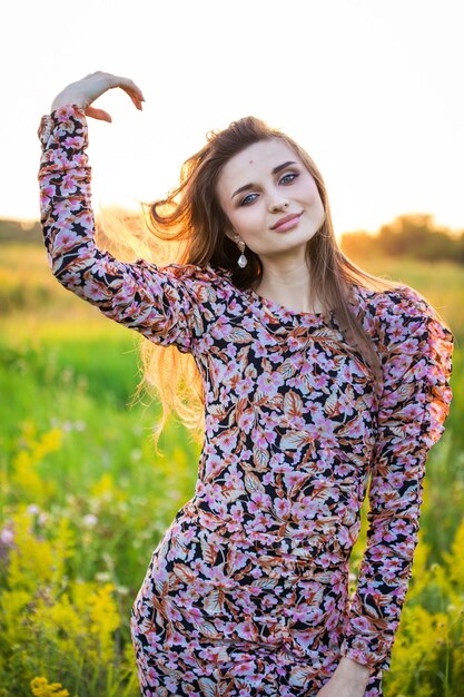 Portrait of a beautiful young girl in colored dress, outdoors, in the field