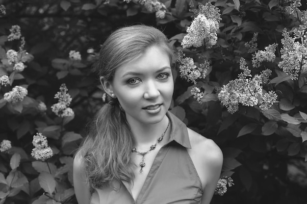 Portrait of a beautiful young girl in the park. lilac blossoms