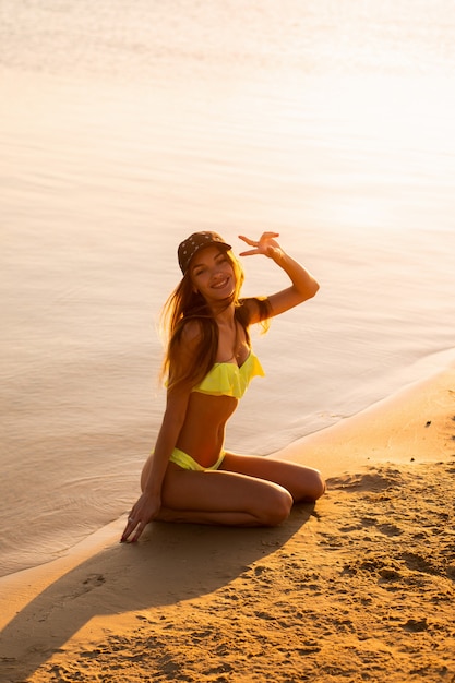 Portrait of beautiful young girl in the sea at sunset