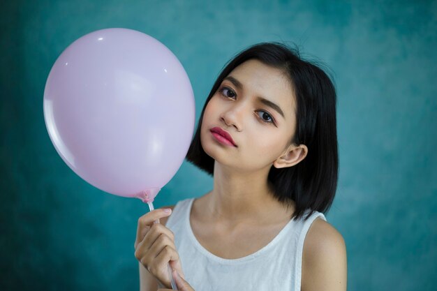 Portrait beautiful young girl wear white dress hold pink balloon