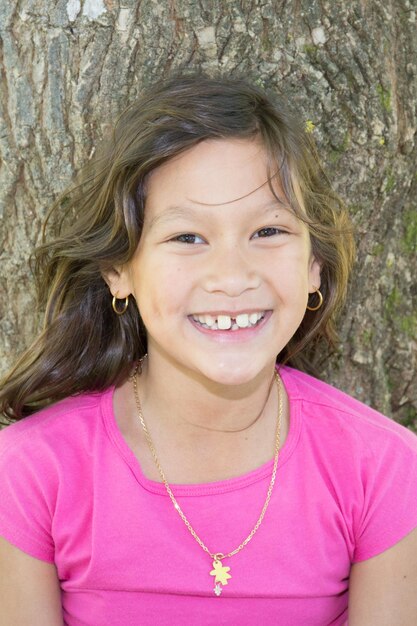 Photo portrait of a beautiful young girl who laughs with her pink tshirt