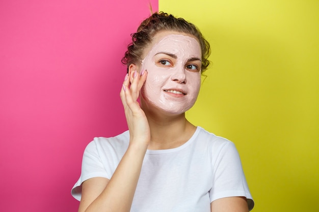 Portrait of a beautiful young girl who puts a refreshing mask on her face to rejuvenate and tone the skin. Beauty treatments