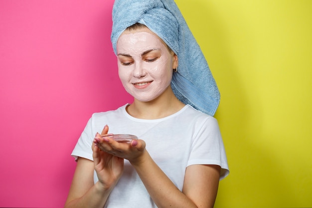 Portrait of a beautiful young girl who puts a refreshing mask on her face to rejuvenate and tone the skin. Beauty treatments