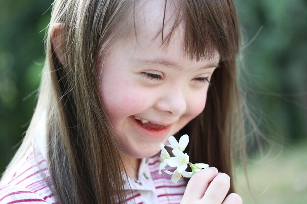 Portrait of beautiful young girl with flowers in the park