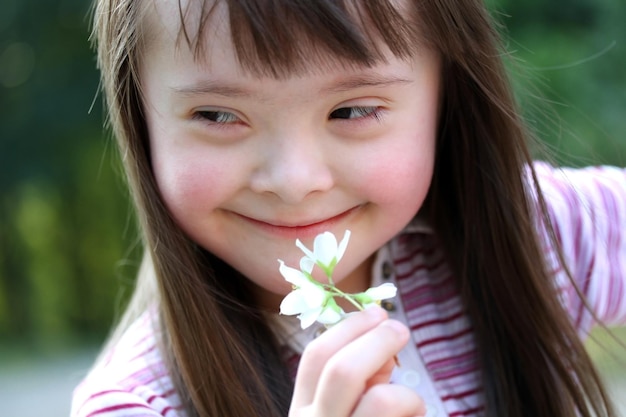 Portrait of beautiful young girl with flowers in the park