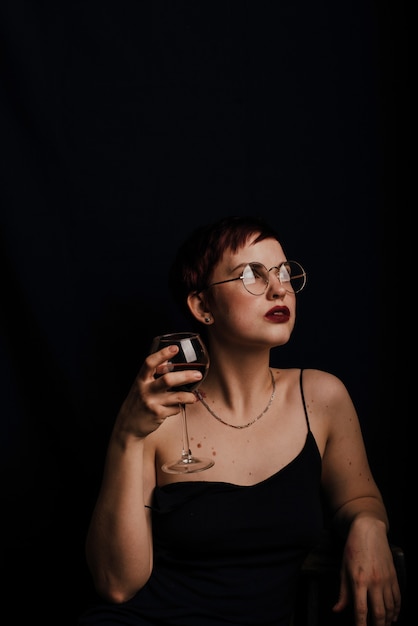 Portrait of a beautiful young girl with a glass of red wine