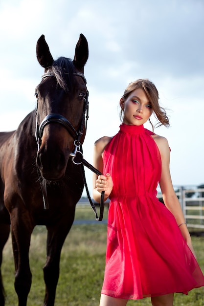 Portrait of a beautiful young girl with a horse