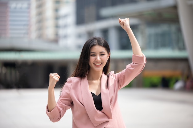 Portrait of beautiful young lady standing against blurred background and looking away at c