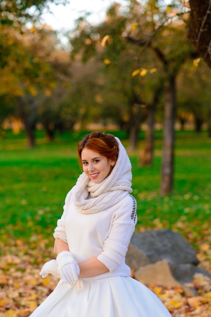 Portrait of a beautiful young redhead girl with flowers look attractive in a white dress