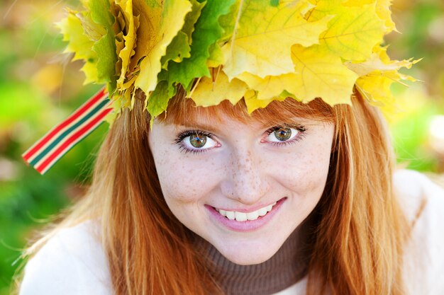 Portrait of a beautiful young redhead teenager woman in a wreath