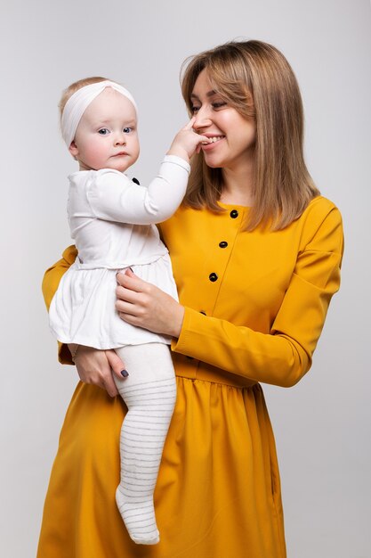 Ritratto di una bellissima giovane madre sorridente con un bambino in braccio