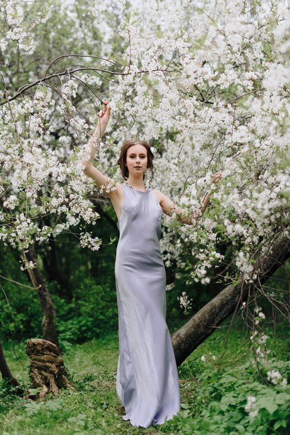 Portrait of a beautiful young thin white girl on a spring cherry blossom 1