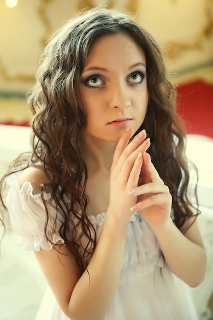 Portrait of a beautiful young victorian lady in white dress