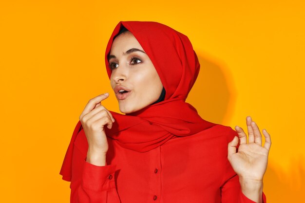 Portrait of beautiful young woman against red background