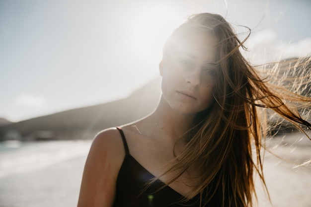 Portrait of beautiful young woman against sky