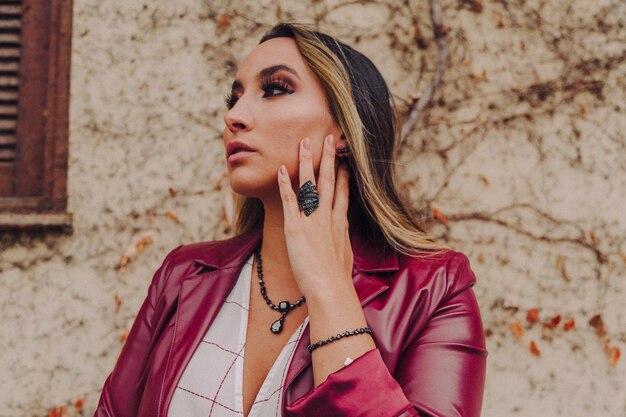 Portrait of beautiful young woman against wall