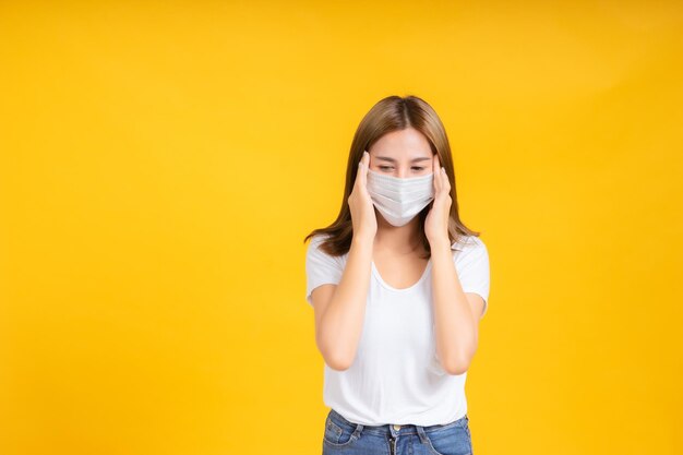 Portrait of beautiful young woman against yellow background