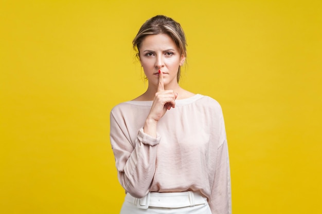 Portrait of beautiful young woman against yellow background