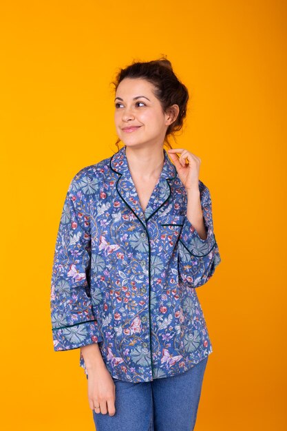 Portrait of beautiful young woman against yellow background