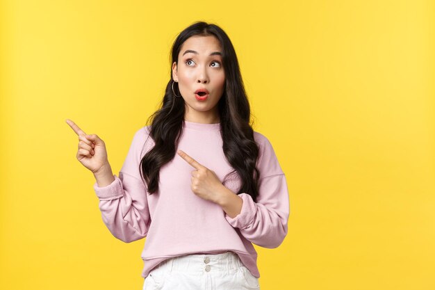 Portrait of a beautiful young woman against yellow background