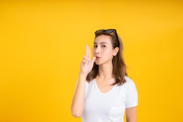 Portrait of beautiful young woman against yellow background