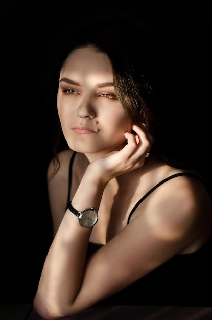 Portrait of a beautiful young woman on a black background