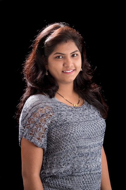 Portrait of beautiful young woman on black wall