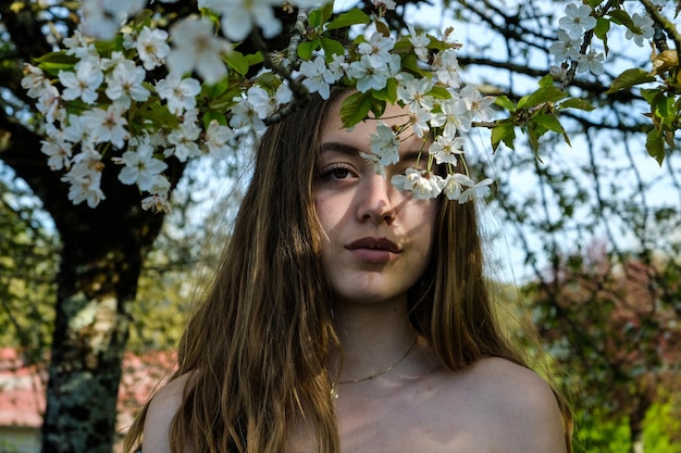 Портрет красивой молодой женщины у цветочного дерева