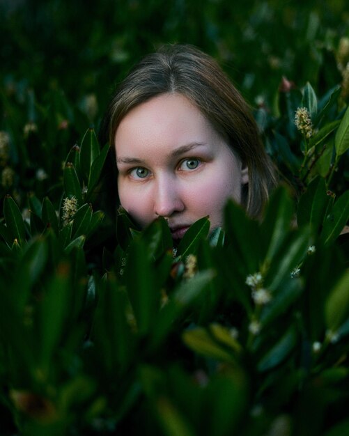 Portrait of beautiful young woman by plants