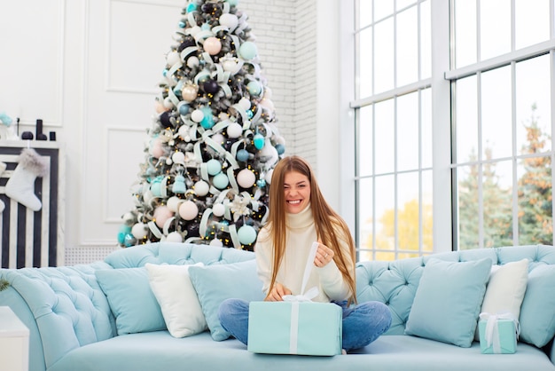 portrait of a beautiful young woman in christmas on the background of a christmas tree