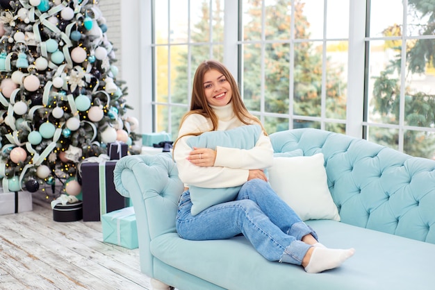 portrait of beautiful young woman in christmas at home on sofa