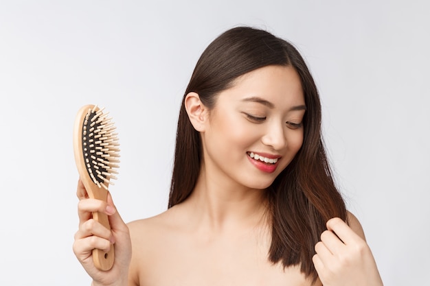 Portrait of a beautiful young woman comb wonderful hair isolated on white background, asian beauty