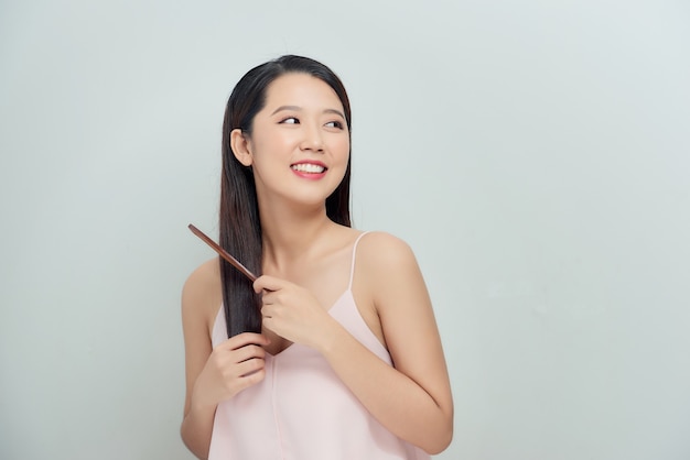 Portrait of a beautiful young woman combing her hair