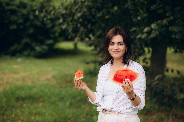 수박을 먹고 있는 아름다운 젊은 여성의 초상화 고품질 사진