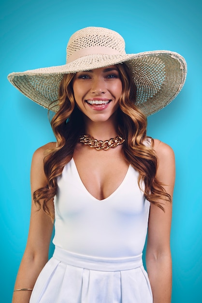 Portrait of beautiful young woman in elegant hat looking at camera and smiling