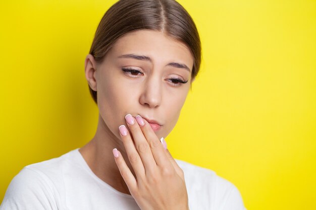 Portrait of a beautiful young woman experiencing a painful toothache.