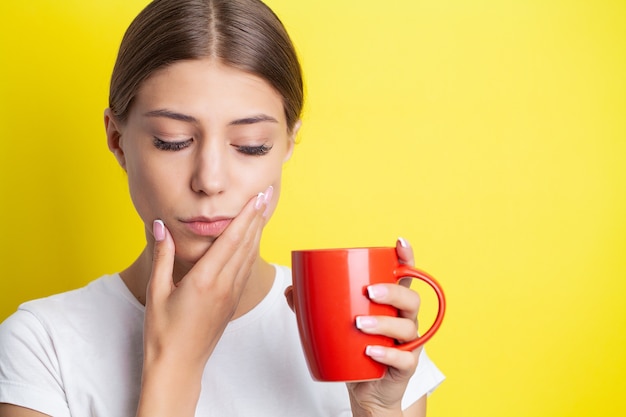 Photo portrait of a beautiful young woman experiencing a painful toothache.