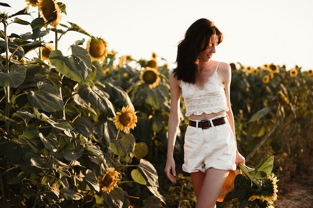 Portrait of beautiful young woman in a field of sunflowers