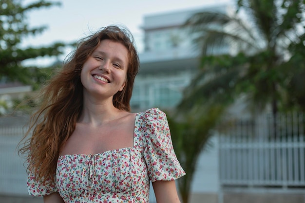 Portrait of a beautiful young woman next to the house on the street